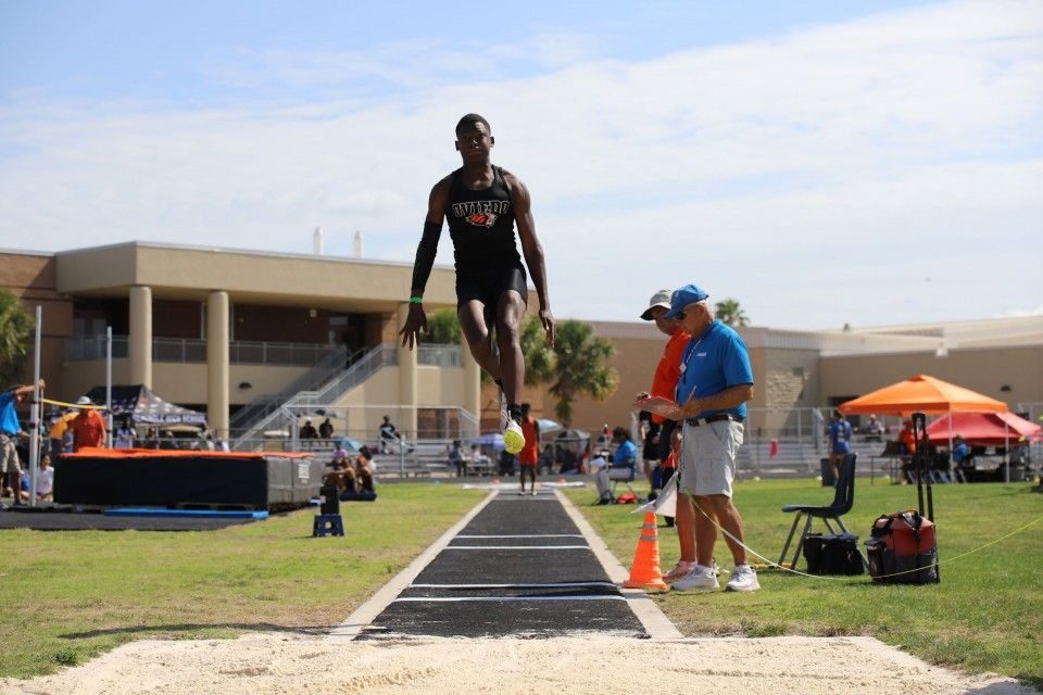 Taylor Royster in mid-flight during a long jump at an Oviedo High School track meet